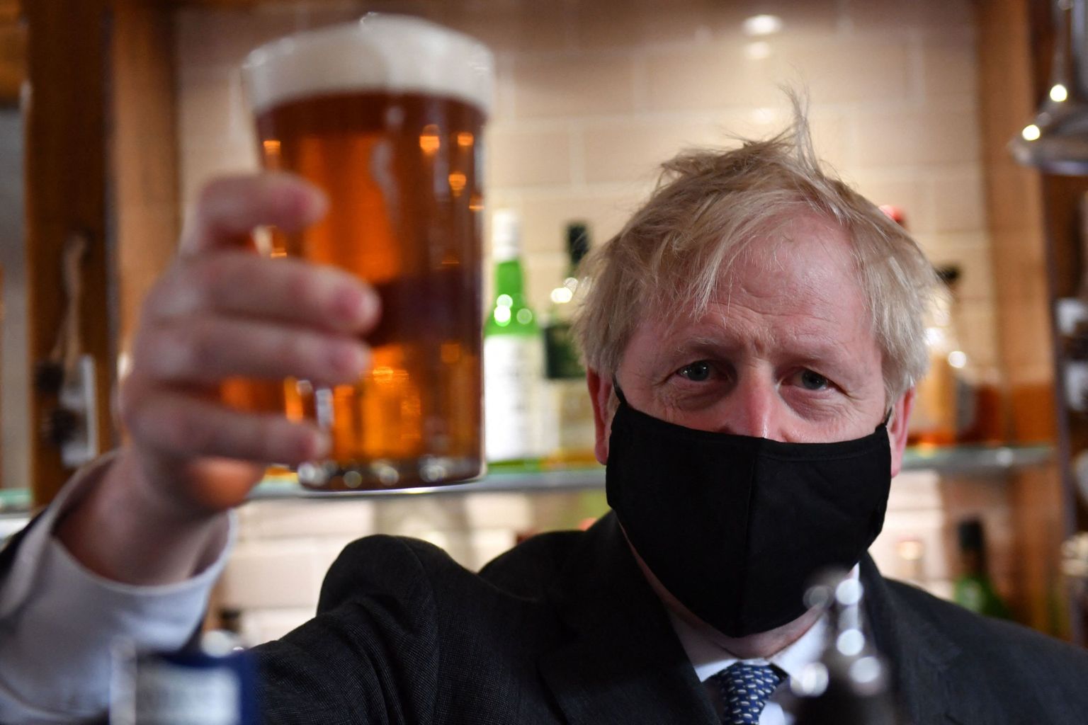 Suurbritannia peaminister Boris Johnson 19. aprillil 2021 Wolverhamptoni pubis The Mount Tavern maski ja õllekese tagant kaamerasse vaatamas.