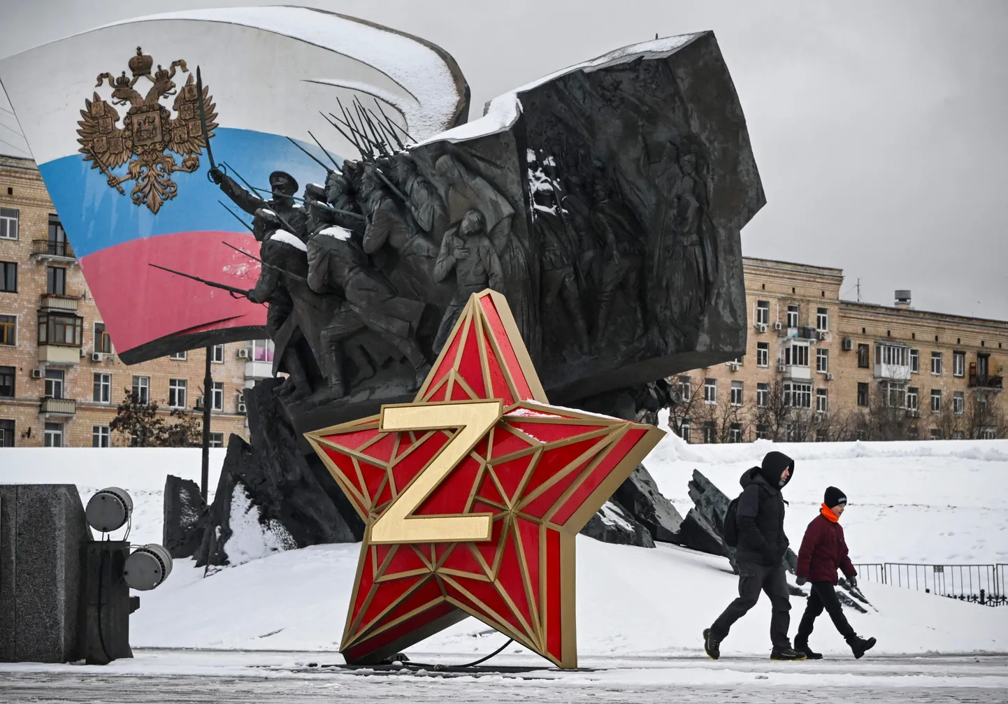 TOPSHOT - People walk past a New Year decoration - Kremlin Star, bearing a Z letter, a insignia of Russian troops in Ukraine, in front of the Monument dedicated to Heroes of the WWI, in western Moscow, on December 26, 2023. (Photo by Alexander NEMENOV / AFP)