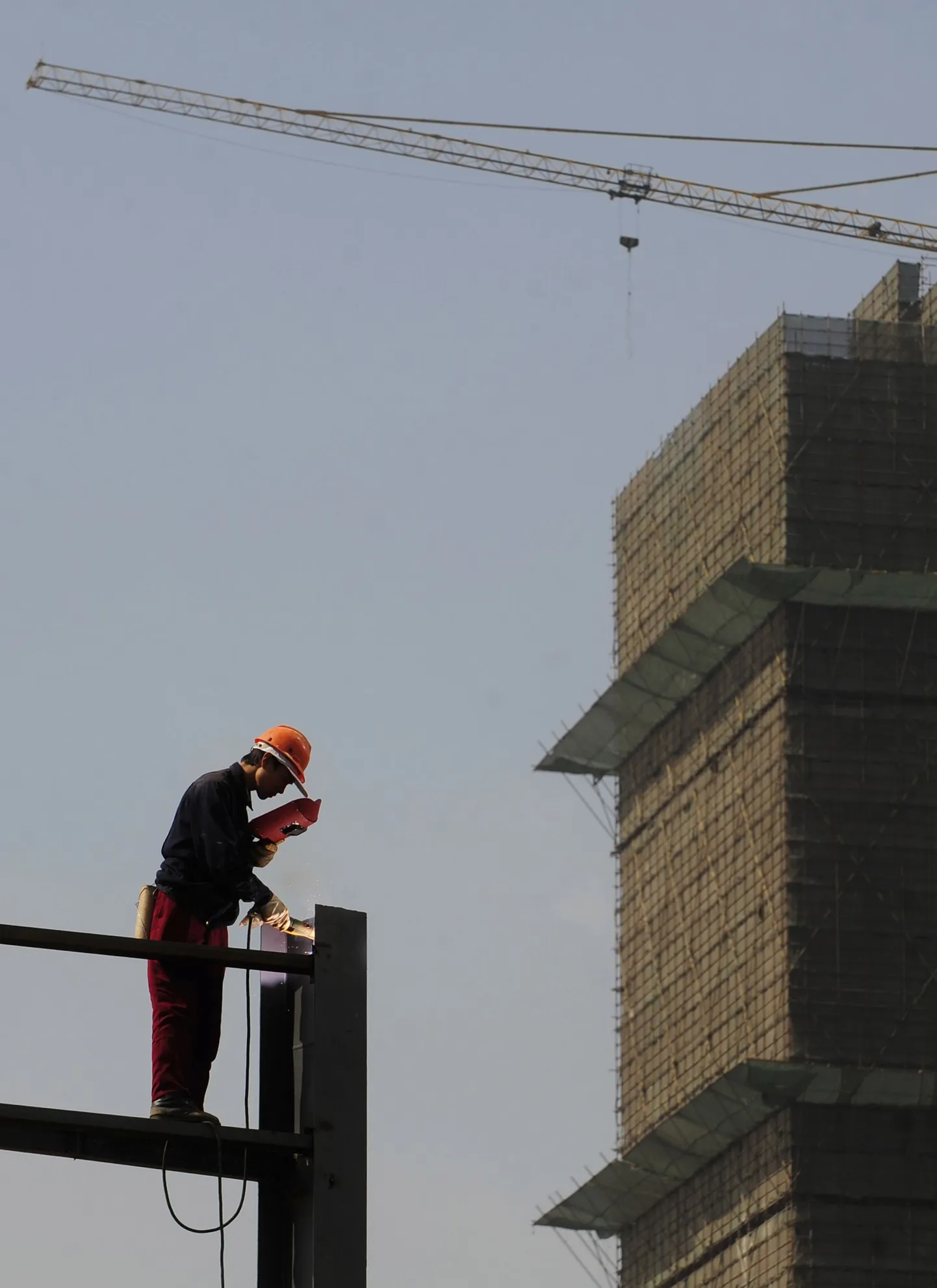 Ehitustööline Hiina Anhui provintsis Hefeis kinnisvaraprojekti reklaami alust keevitamas.