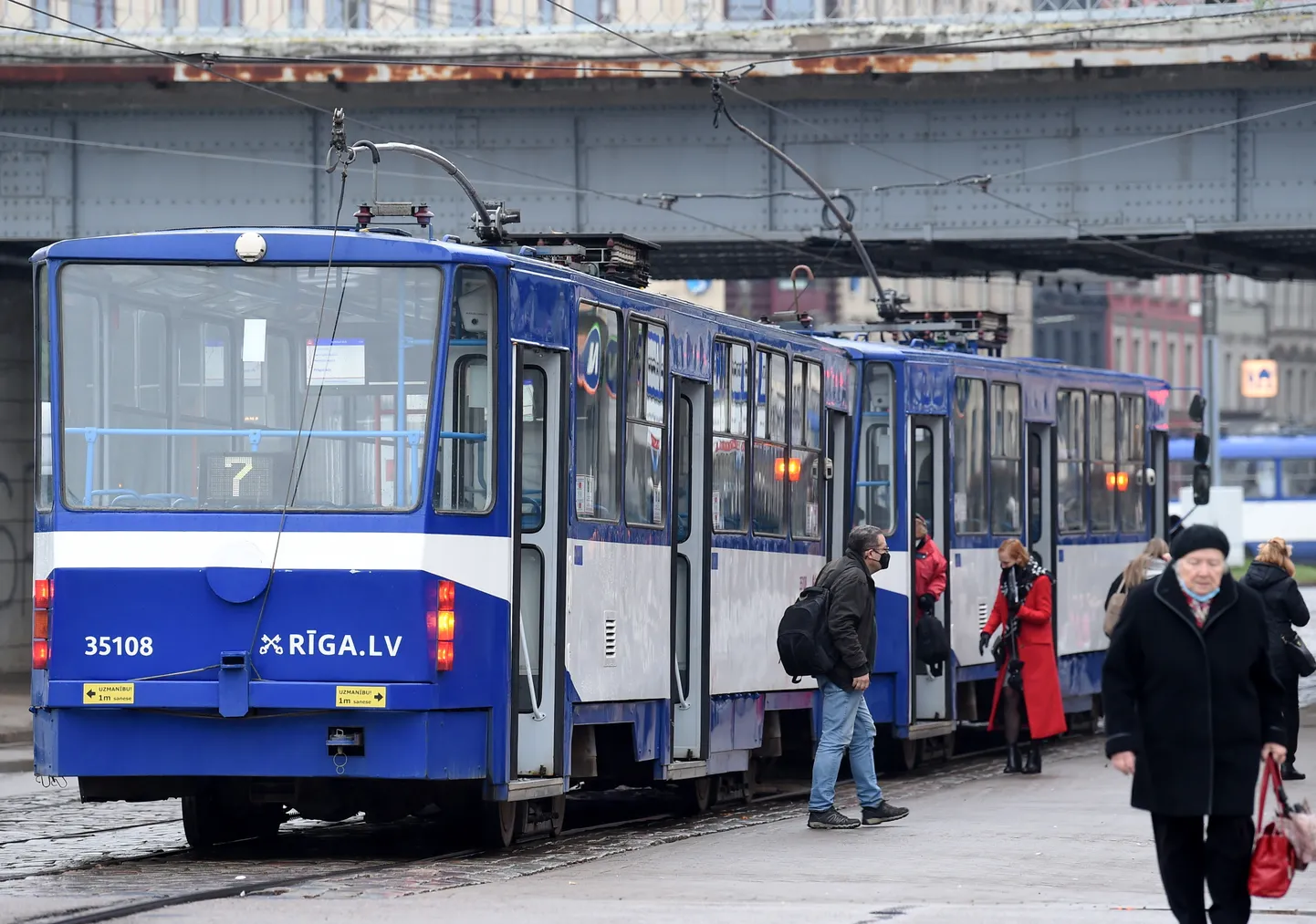 Люди на остановке общественного транспорта в Риге