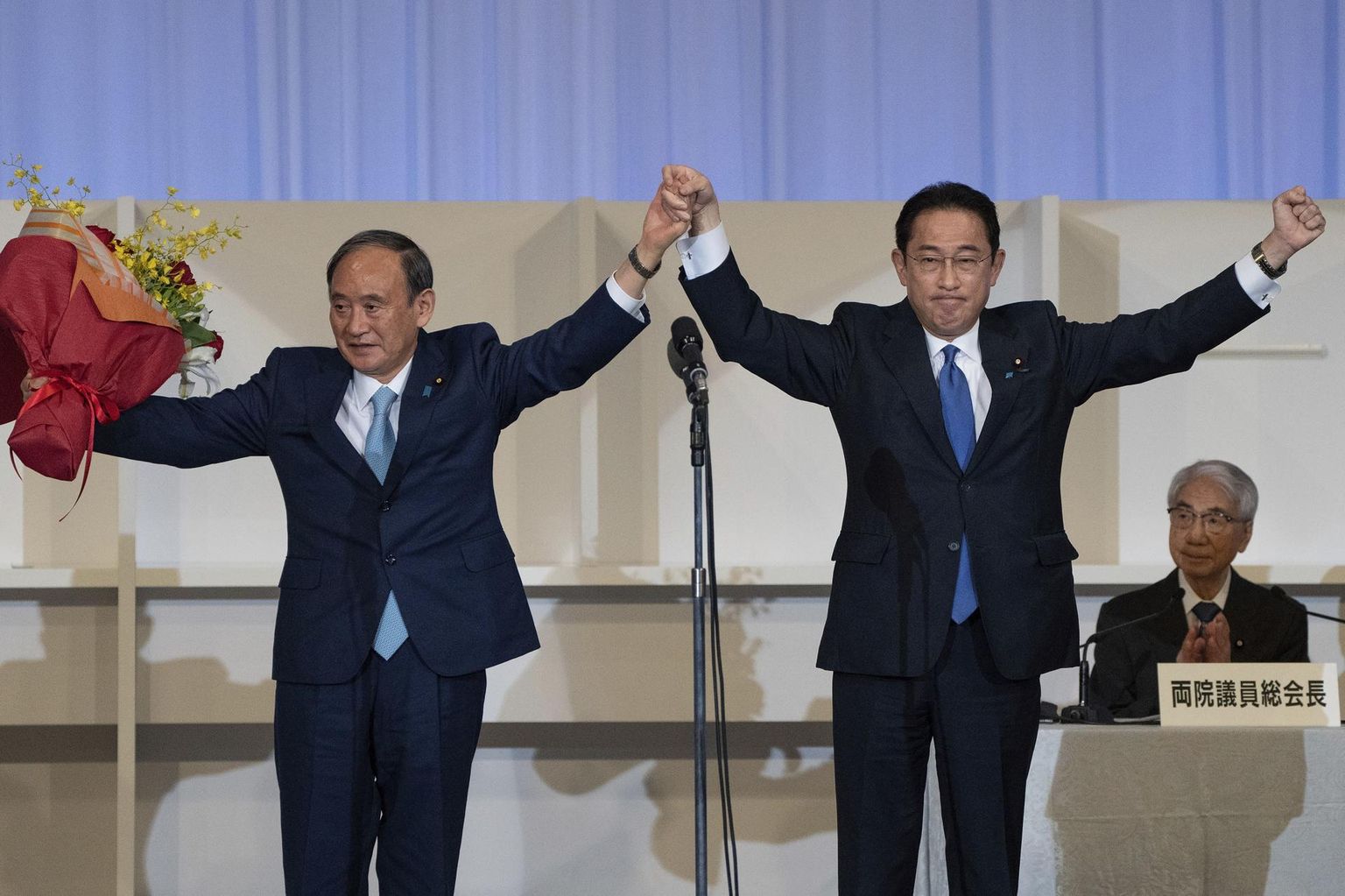 Jaapanit valitseva Liberaaldemokraatliku Partei (LDP) liidriks valitud Fumio Kishida (paremal) tähistamas eile võitu koos oma eelkäija ja ametist lahkuva peaministri Yoshihide Sugaga.
