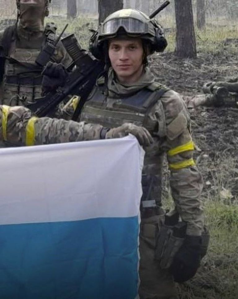 Дани Акель с бело-сине-белым флагом - неофициальным символом антивоенного движения в России.