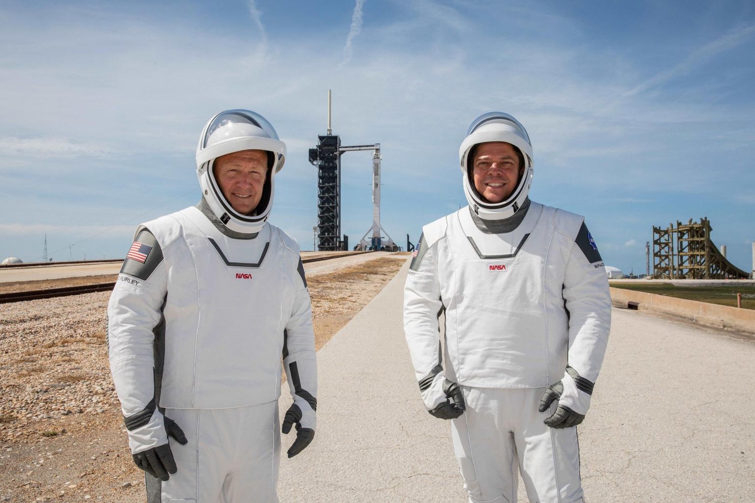 NASA astronaudid Douglas Hurley (vasakul) ja Robert Behnken Kennedy kosmodroomi platvormil 39a seisva kosmosefirma SpaceX raketi Crew Dragoni ees.