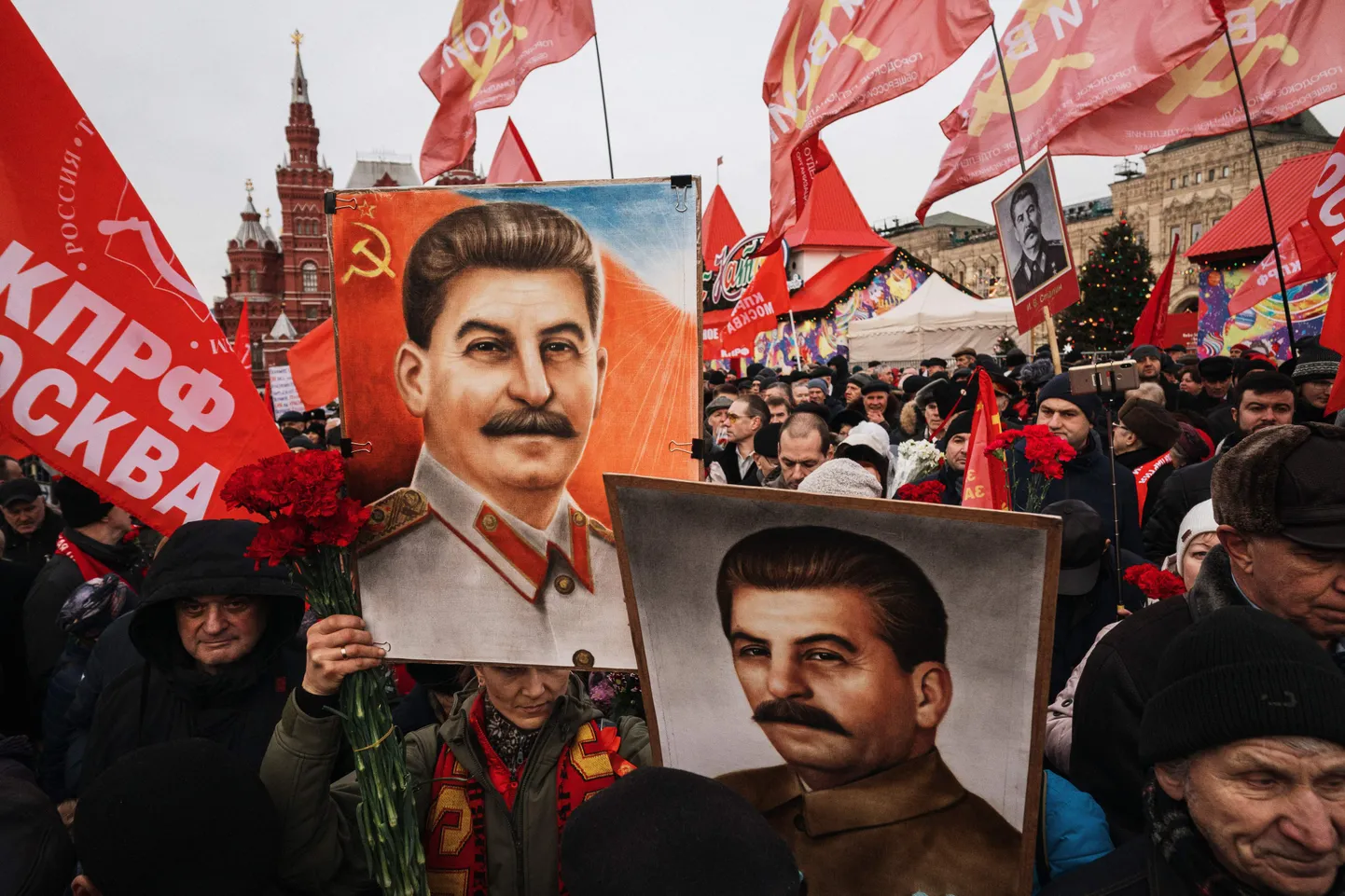 Люди держат портреты советского лидера Иосифа Сталина и ждут, чтобы возложить цветы к его могиле у Кремля на Красной площади в Москве 21 декабря 2019 года, когда члены различных коммунистических и левых движений собрались, чтобы отметить 140-ю годовщину со дня его рождения.