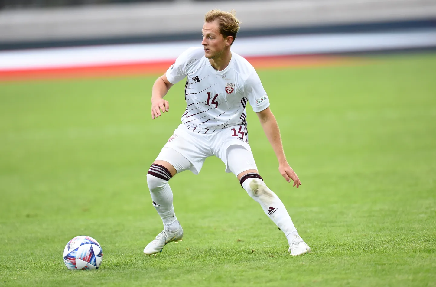 Latvijas futbola izlases spelētājs Andrejs Cigaņiks (nr.14, baltā formas tērpā) UEFA Nāciju līgas spēlē futbolā starp Latvijas un Andoras izlasēm Daugavas stadionā.