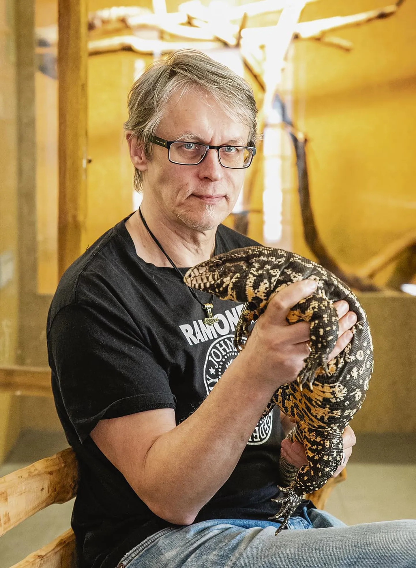 Argen­tina tegu, pisikene krokodillilaadne elukas laseb ennast süllegi võtta.