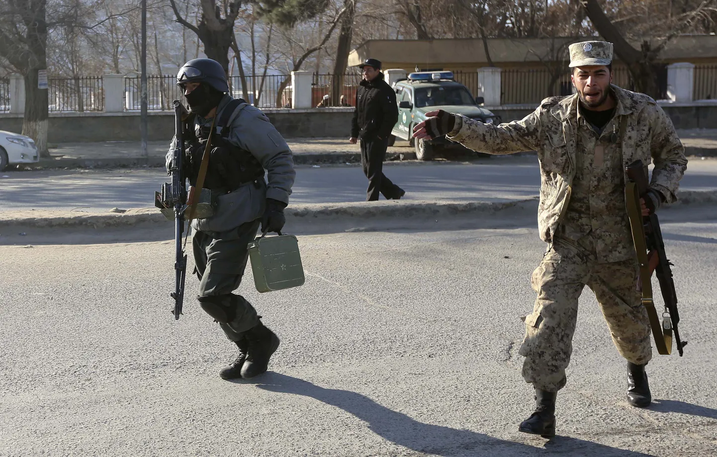 Afganistani politseinikud täna hommikul jooksmas rünnaku alla sattunud Kabuli liikluspolitsei peahoonesse.