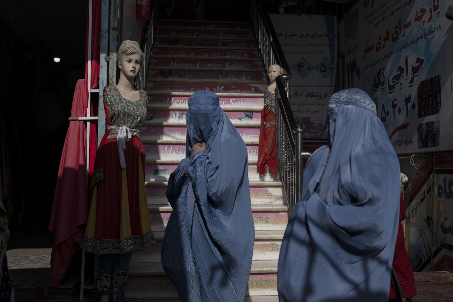 Burkasse riietatud afgaani naised rõivapoe juures Heratis tänavu novembris. Talibani uue korralduse kohaselt ei tohi poes rõivaid reklaamivatel mannekeenidel enam päid olla.