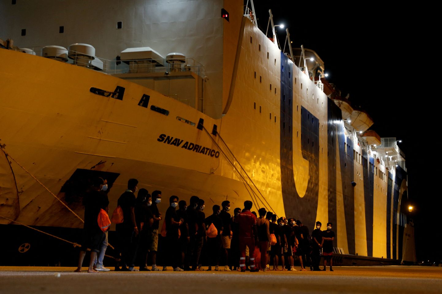 Migrandid suunduvad karantiinilaeva Snav Adriatico poole pärast Sitsiiliasse jõudmist 7. august 2021.