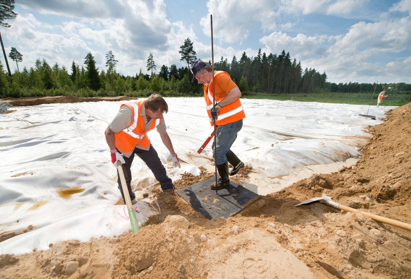 Artu Ellmann ja Innar Metsala TTÜ Teedeinstituudist paigaldavad metallplaate, mille abil mõõdetakse tee aluse turbapinna vajumist.