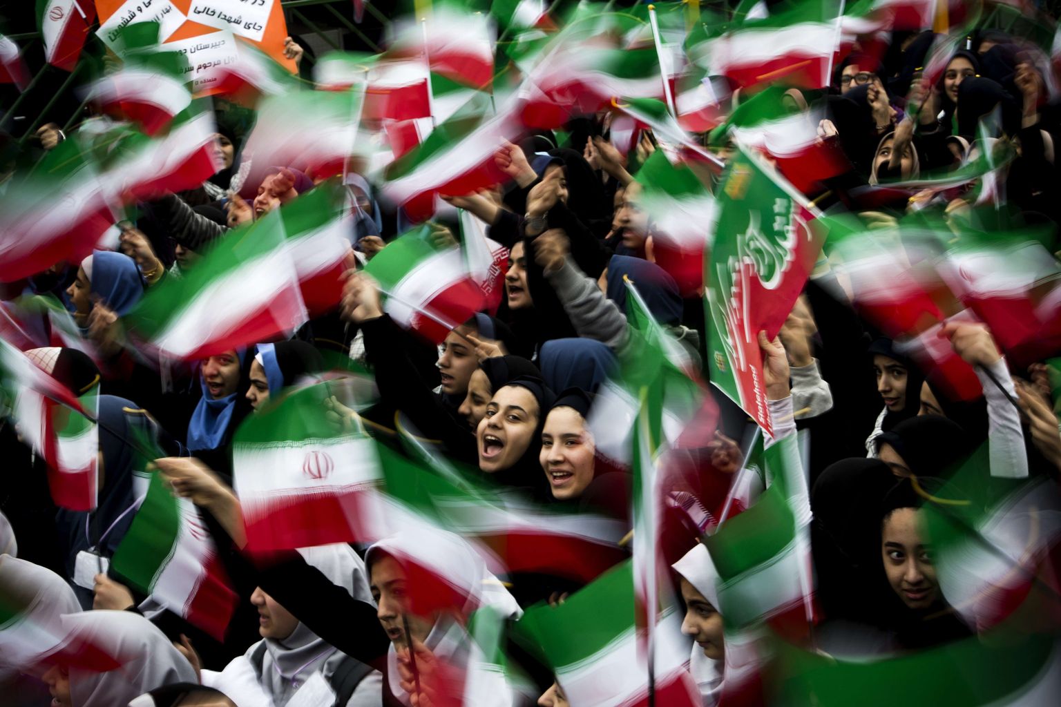 Iraani koolitüdrukud lehvitavad lippudega Islamirevolutsiooni 36. aastapäeval Teheranis. Pilt on illustratiivne.