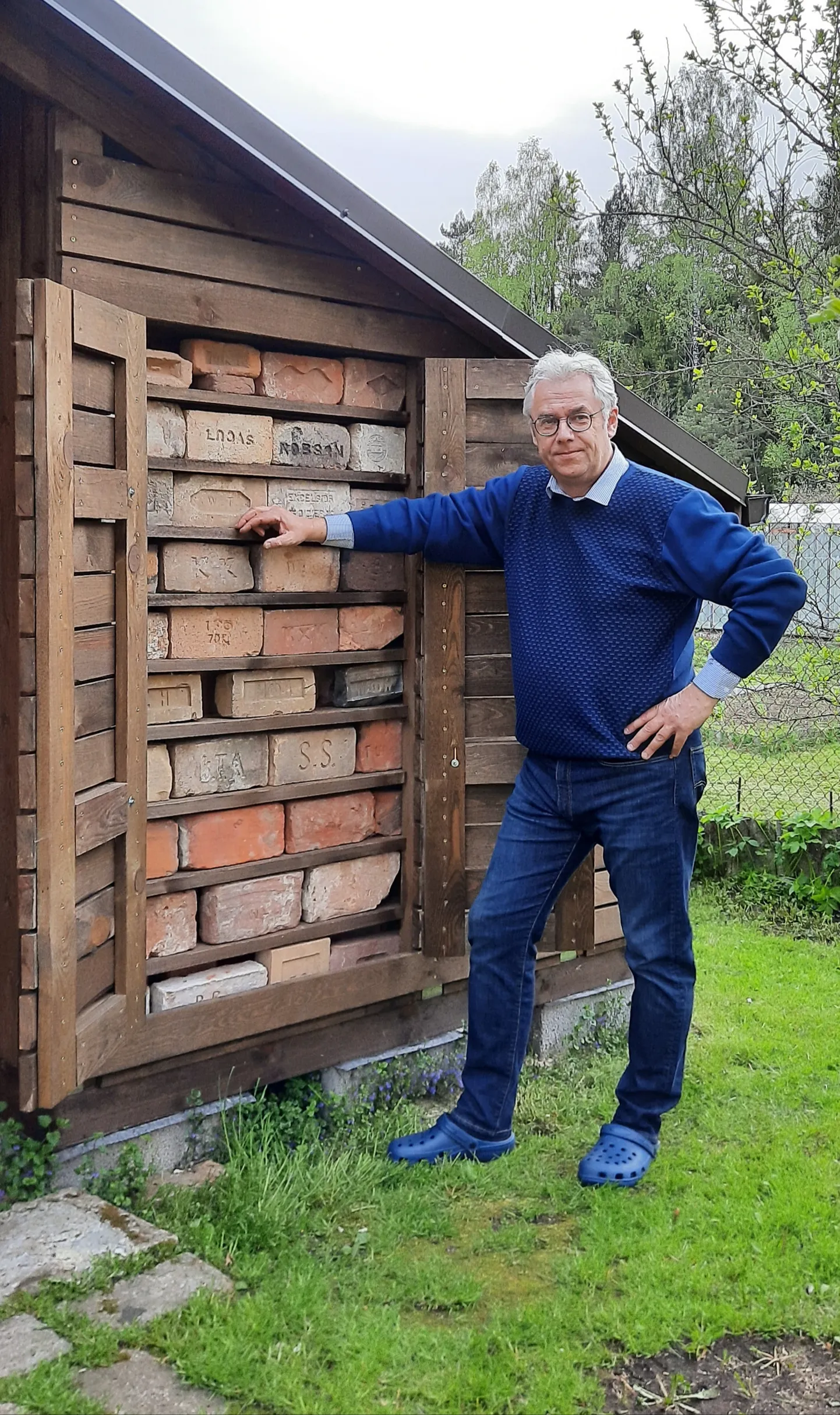 Юрий Перевощиков на фоне своей краеведческой коллекции клейменных кирпичей. Они попадаются не часто, но могут многое рассказать о прошлом Риги.