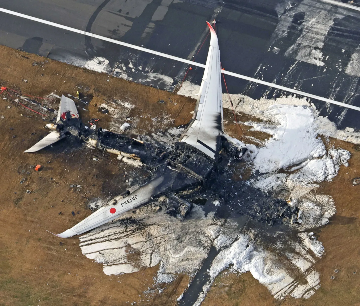 Вид с воздуха показывает сгоревший самолет Airbus A350 авиакомпании Japan Airlines (JAL) после столкновения с самолетом береговой охраны Японии в международном аэропорту Ханэда в Токио, Япония, 3 января 2024 года.