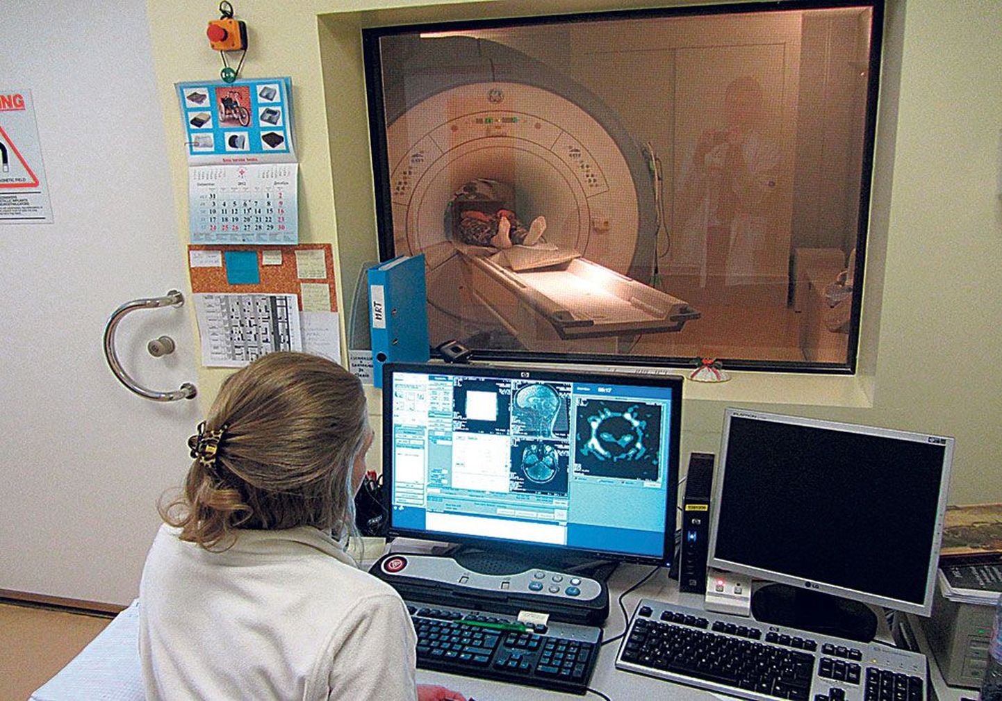 В магнитно-резонансном томографе пациент лежит на спине в трубе аппарата диаметром примерно 60 см и длиной около двух метров. Радиолог наблюдает за процессом через окошко.