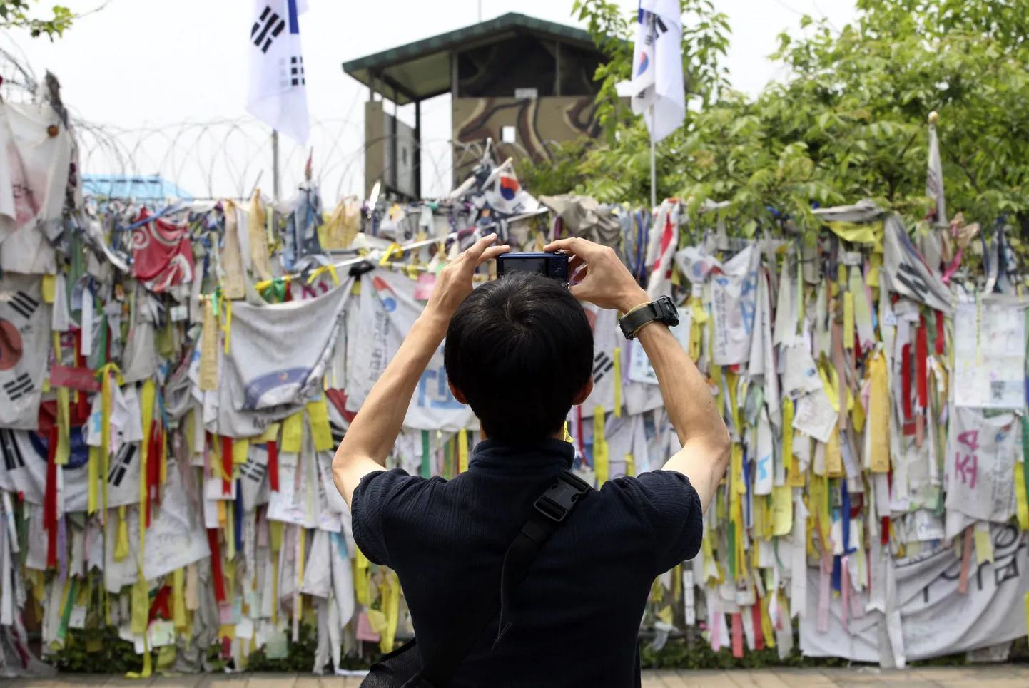 Külastaja teeb pilti Panumnjomi piiriküla lähedal asuvast Imjingaki paviljoni aiast, kuhu on riputatud paelu ja kangaid kahe Korea ühinemist soovivate tekstidega.