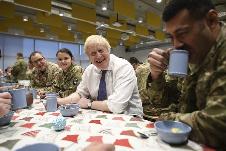 Britain's Prime Minister Boris Johnson enjoys Christmas lunch with British troops stationed in Estonia during a one-day visit to the Baltic country, in Tallinn, Saturday, Dec. 21, 2019. (Stefan Rousseau/Pool photo via AP)