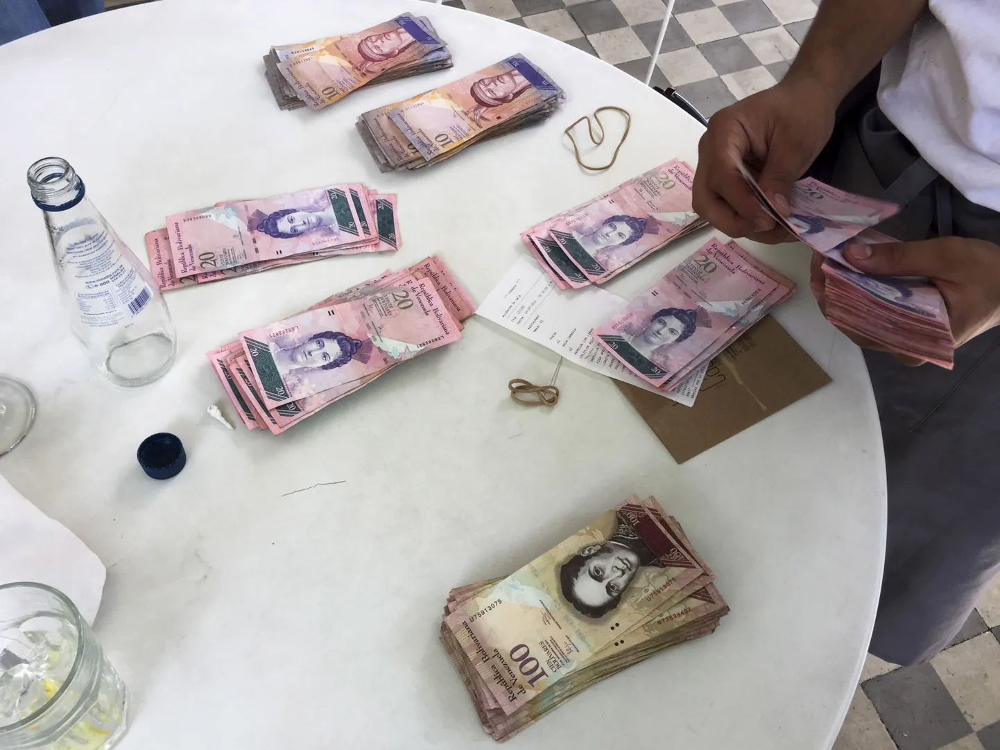 Kelner Caracase restoranis raha lugemas. Nelja inimese lõuna maksis 13 126 bolivari ehk üle 1800 euro ametliku kursi järgi, aga musta turu kursi järgi vaid 17 eurot.