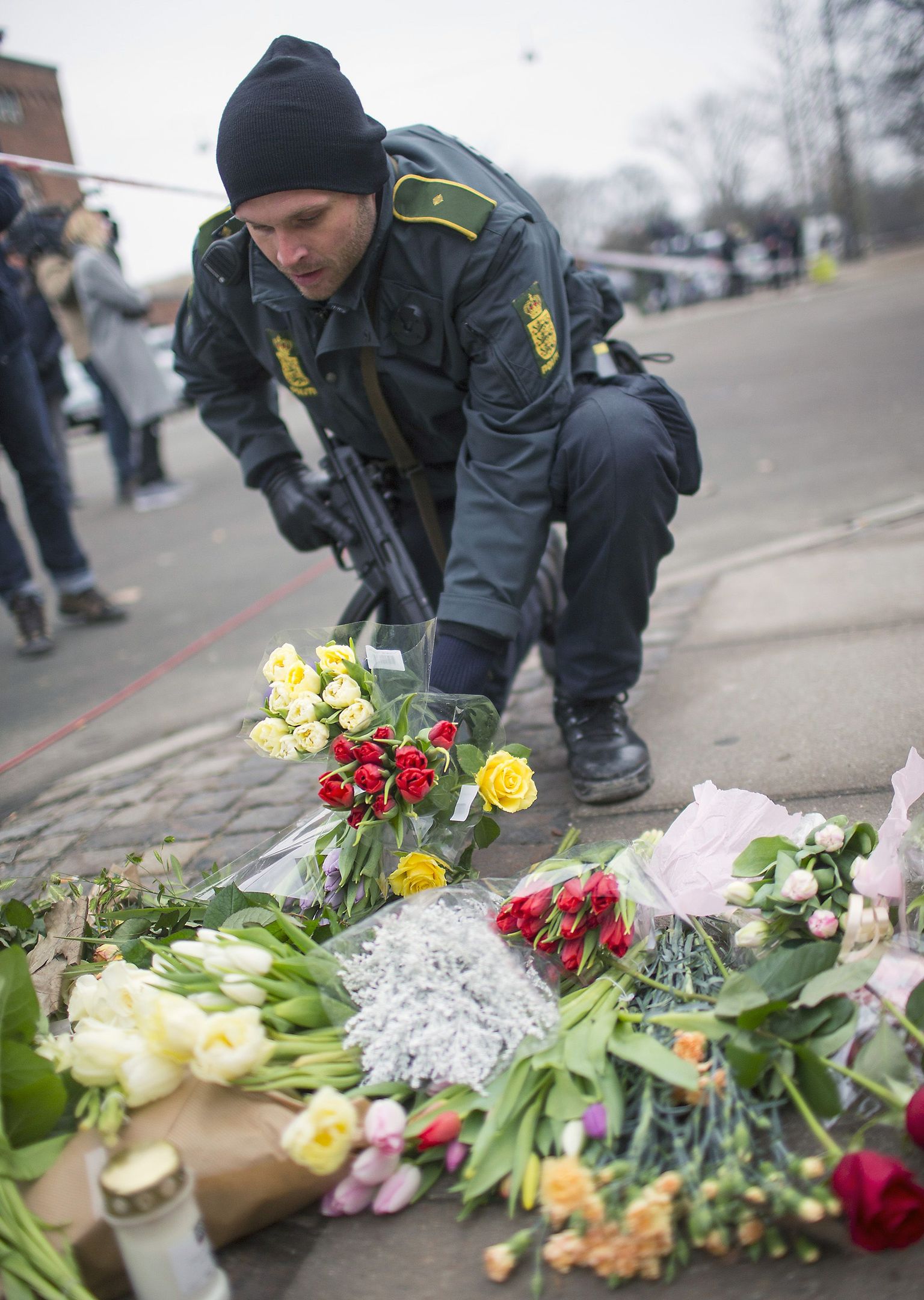 Taani politseinik asetamas lilli Krudttondeni kultuurikeskuse juurde.