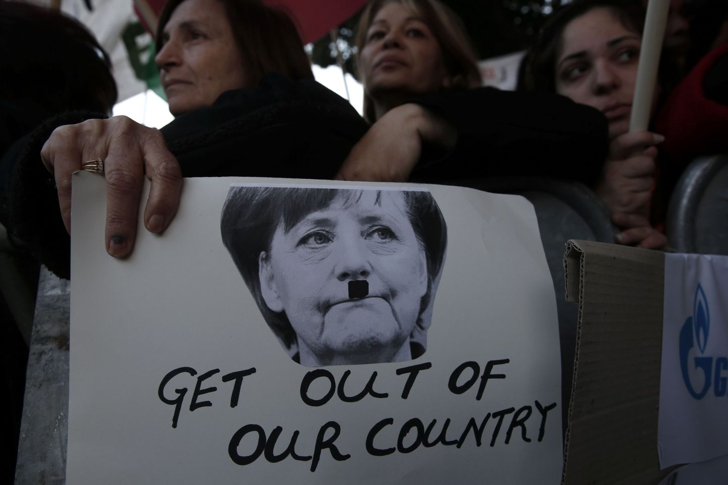 Küprose parlament tõrjus teisipäeval ühehäälselt hoiuste maksustamise tingimuse päästepaketile. Fotol protestijad Angela Merkeli plakatiga, millel viimast on kujutatud Adolf Hitleri vuntsidega.