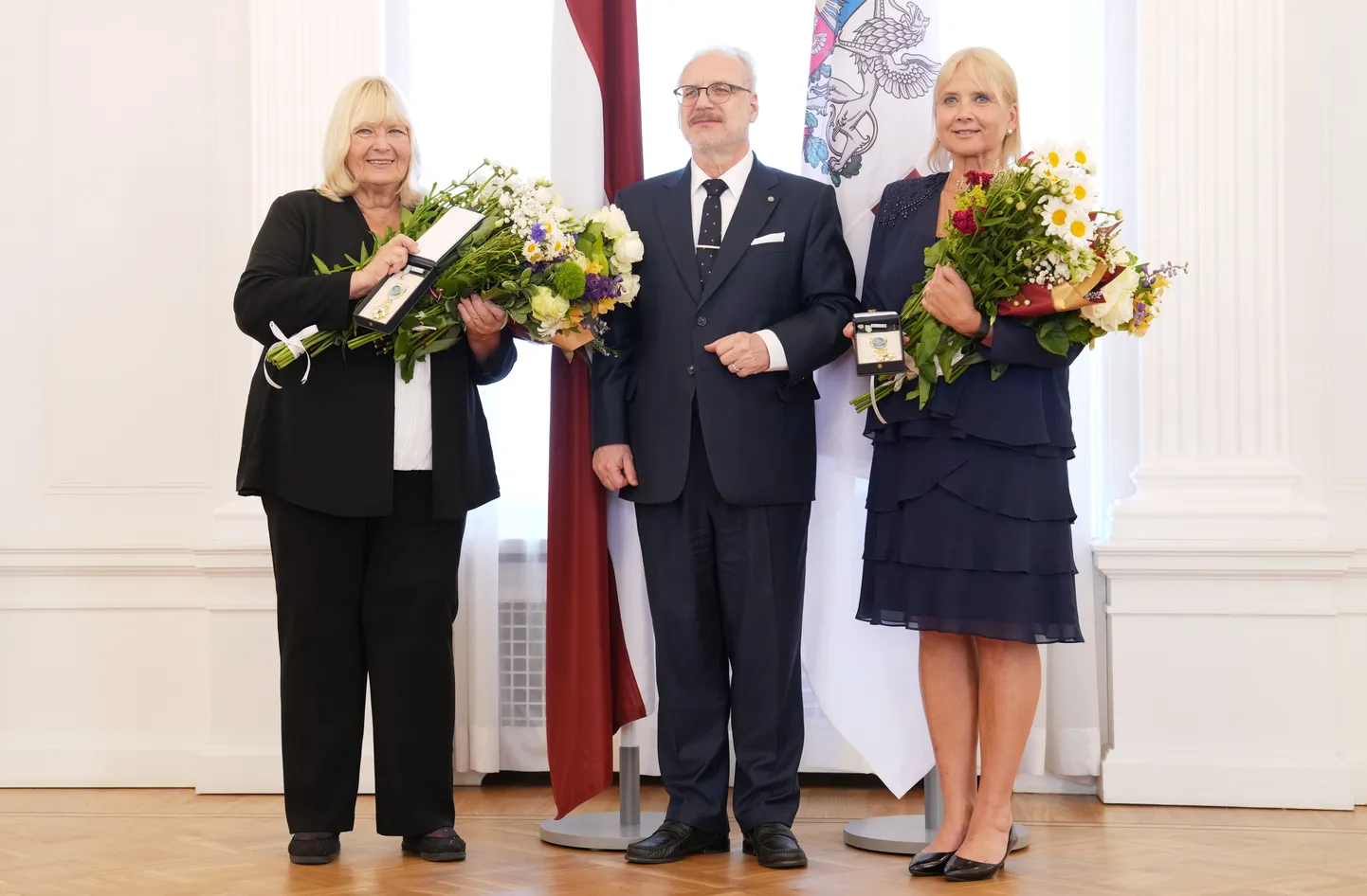Komponistes Brigita (no kreisās) un Lolita Ritmanes fotografējas kopbildei ar Valsts prezidentu Egilu Levitu pēc Triju Zvaigžņu ordeņu saņemšanas Rīgas pilī.