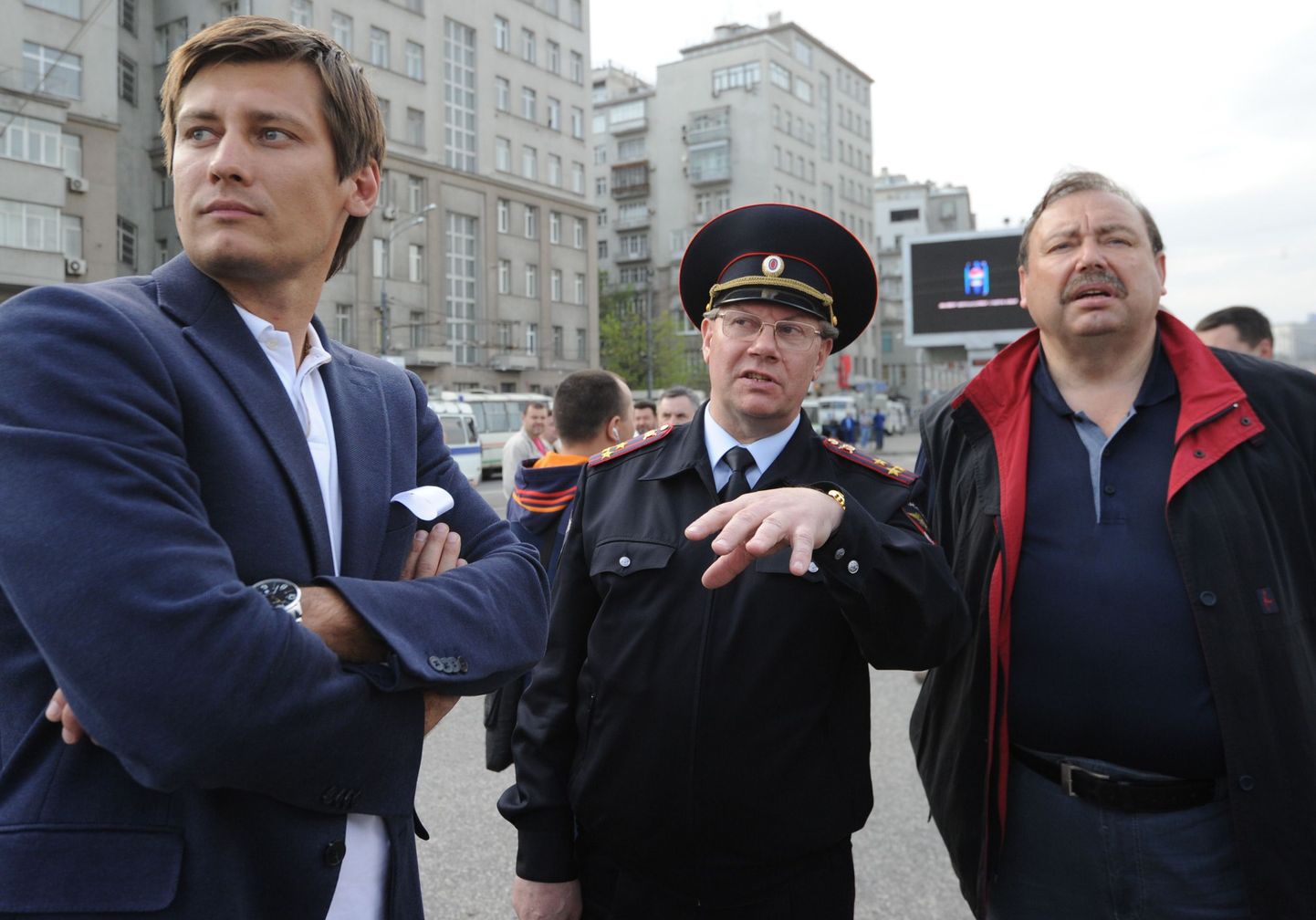 Parlamendisaadik Dmitri Gudkov (vasakul) vestleb koos poliitikust isa Gennadi Gudkoviga korrakaitsejõudude esindajaga.