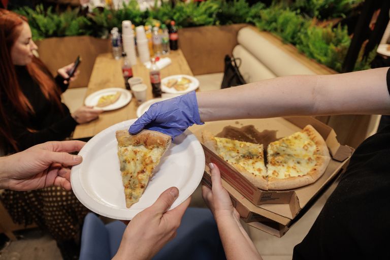 Сервировка пиццы на церемонии открытия в Таллинне ресторана сети Domino's Pizza. 