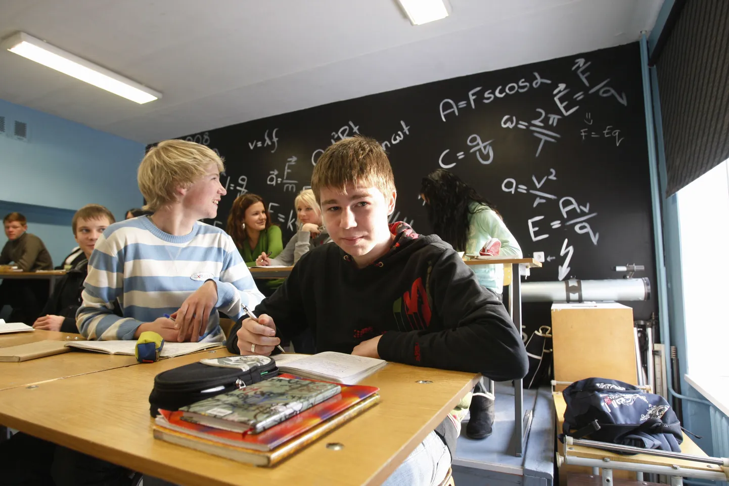Füüsikavalemid Tartu Tamme gümnaasiumi füüsikaklassi seinal. Pildil on esiplaanil Tamme Gümnaasiumi 9b klassi õpilased Kristjan Müürsepp (vasakul) ja Marek Rüütli.