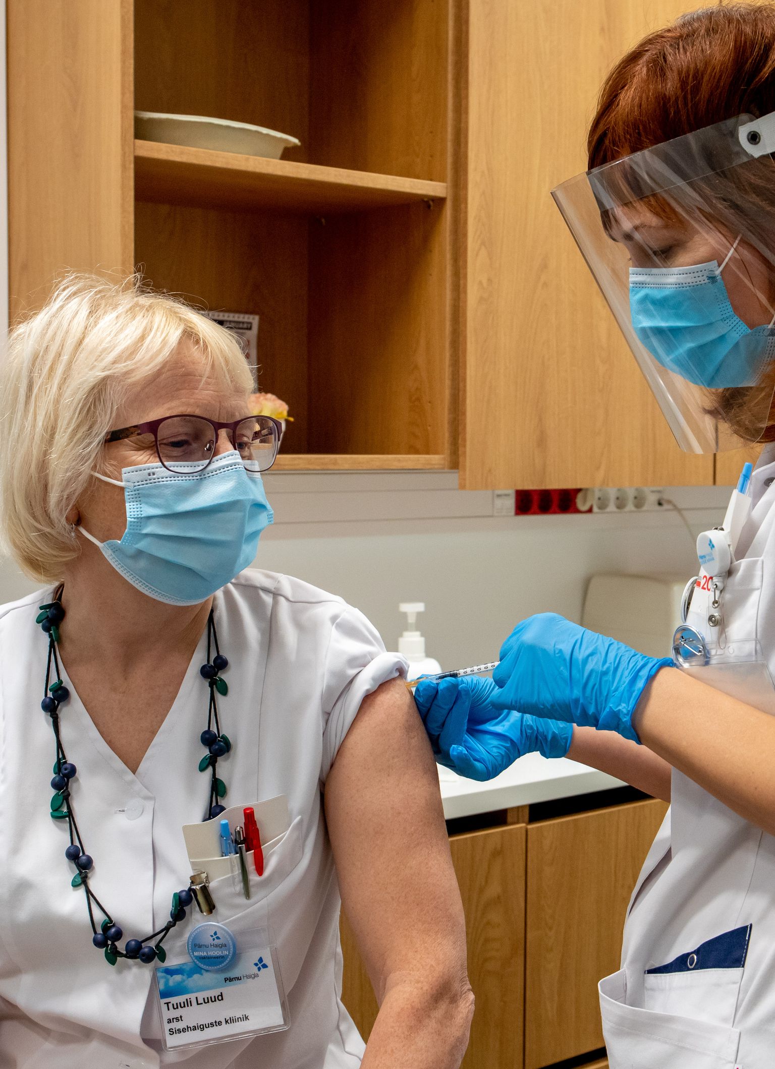 Vaktsineeritud haiglatöötajate töötõenditele lisati pärast süsti vaktsineerimist tõendav punane kleebis.