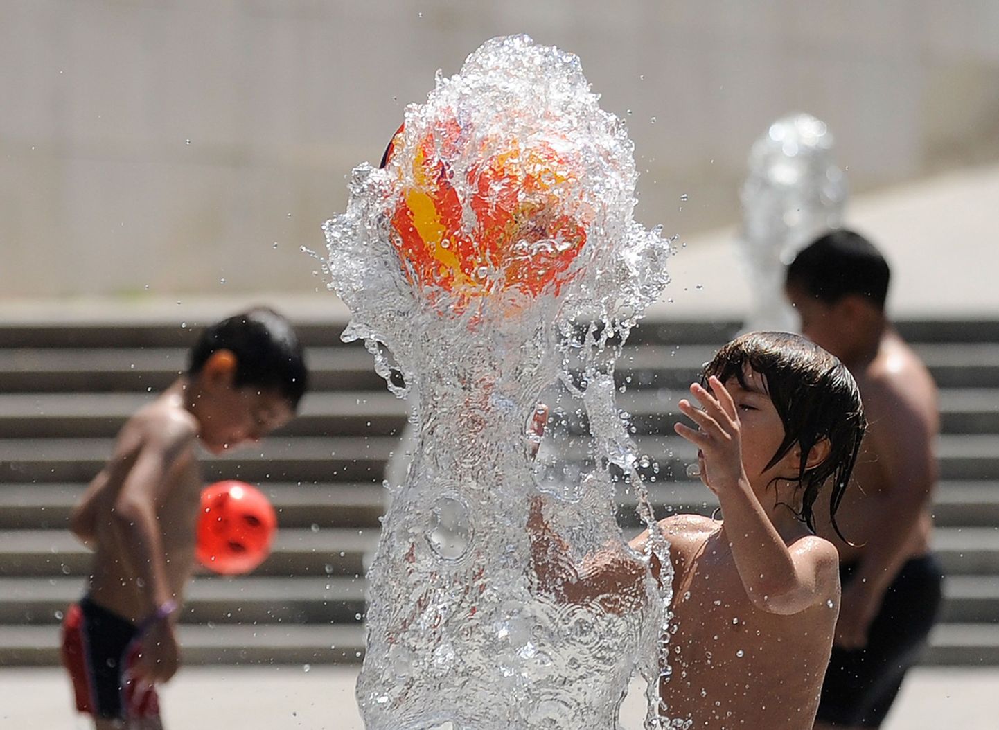 Дети играют в фонтане в столице Испании.