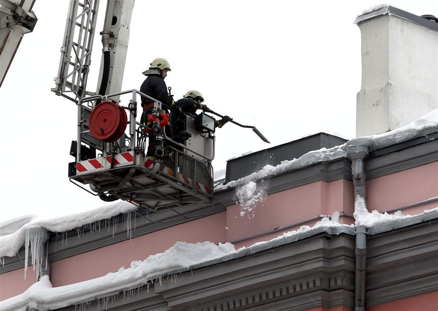 Päästjad koristavad lund ja jääpurikaid Tallinna Keskraamatukogu hoone katuselt Estonia puiesteel.