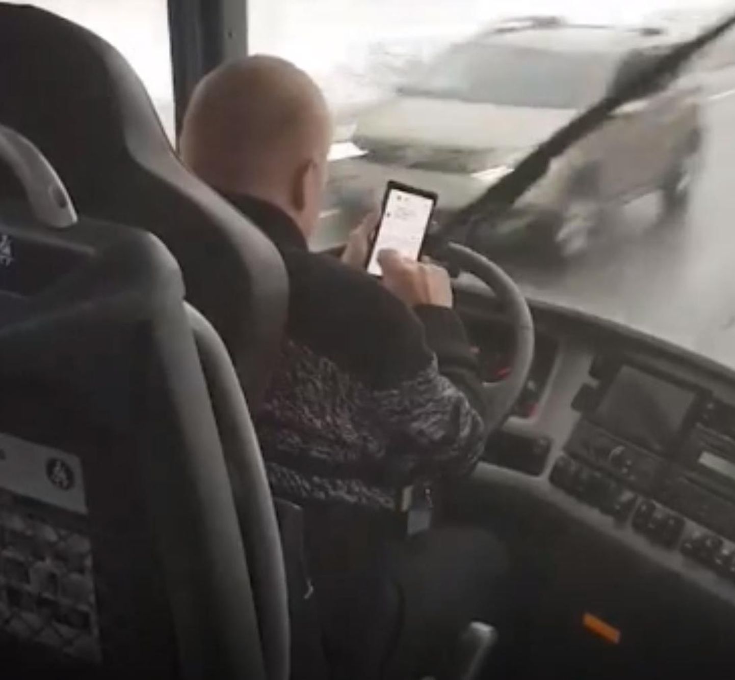 Водитель автобуса пишет СМС за рулем.