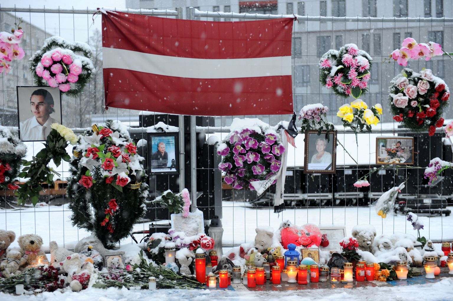 Цветы и свечи на месте обрушения супермаркета "Maxima", где 21 ноября 2013 года погибли 54 человека