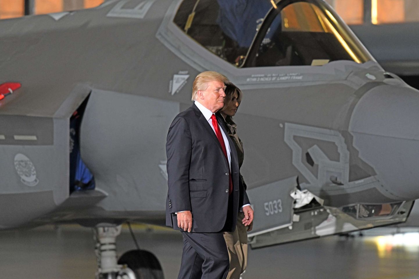 Donald Trump ja Melania Trump F-35 hävitaja taustal.