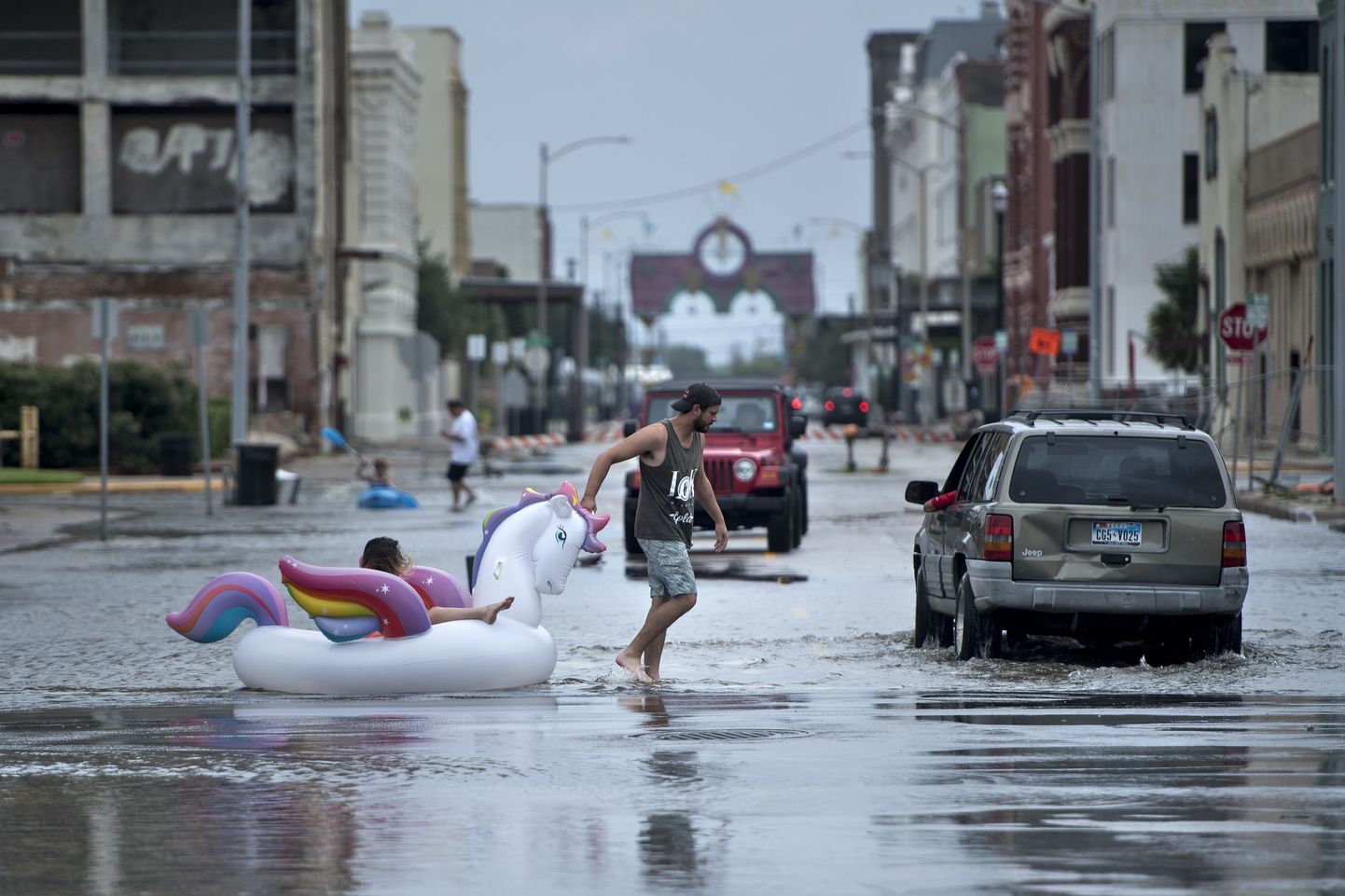 TOPSHOT - People make their way down partially flooded roads following the passage of Hurricane Harvey on August 26, 2017 in Galveston, Texas. / AFP PHOTO / Brendan Smialowski