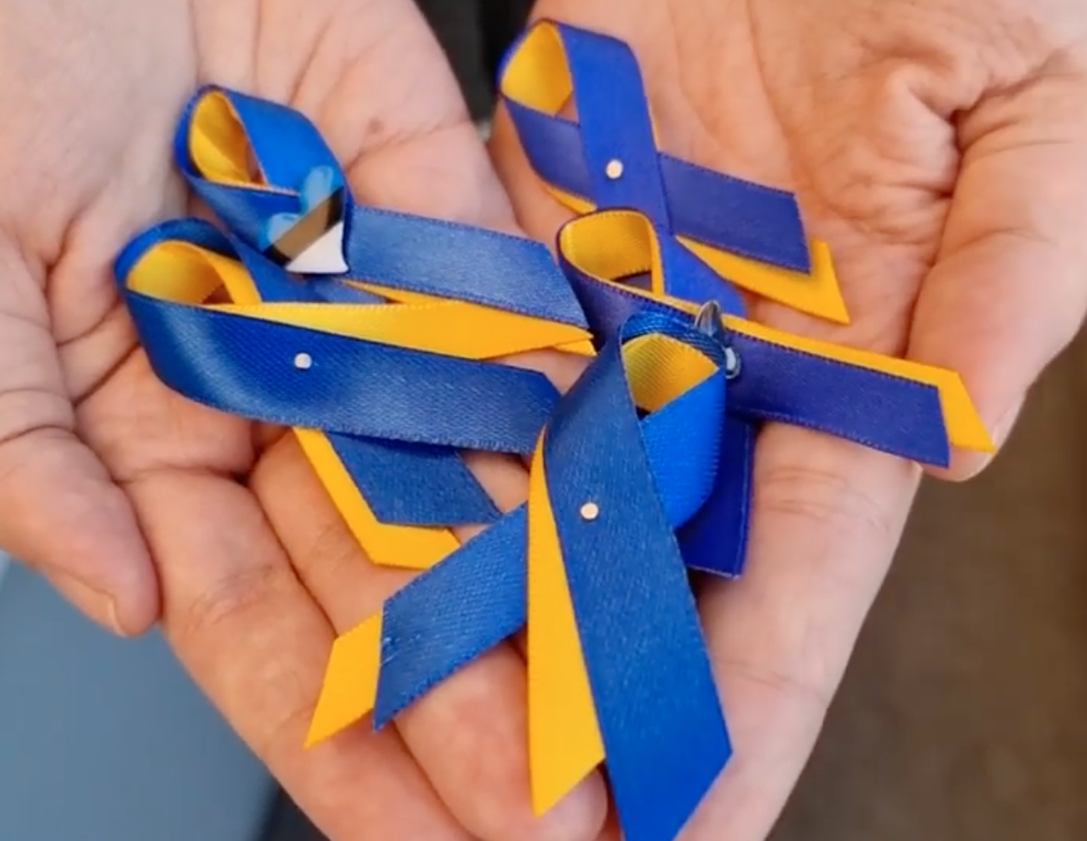 Сине-желтые ленточки носят в поддержку Украины.