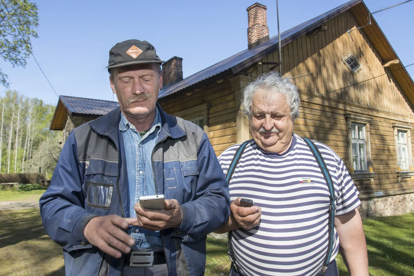 Penuja küla elanikud Aivo Joamets (vasakul) ja Urmas Toom uurivad mobiiltelefoni ekraanilt, kas sidevahend on parasjagu võrgus.