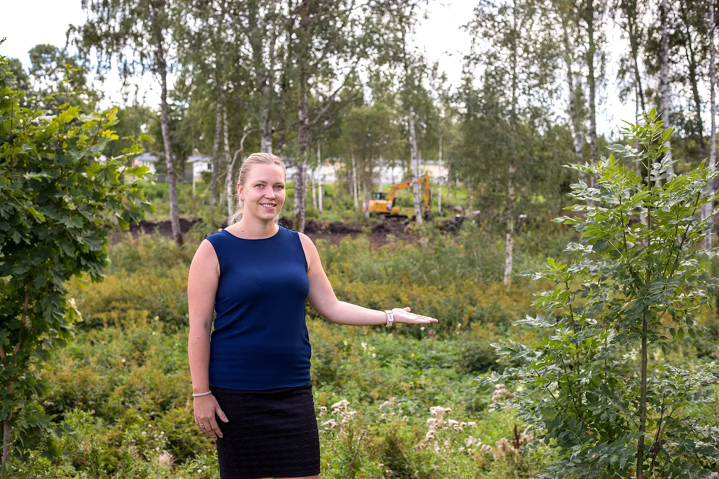 Valjala lasteaia õppejuht Marii Saar  näitab maa-ala, kuhu maaküttetorustik paigaldatakse. Taamal lasteaed ja koolihoone.