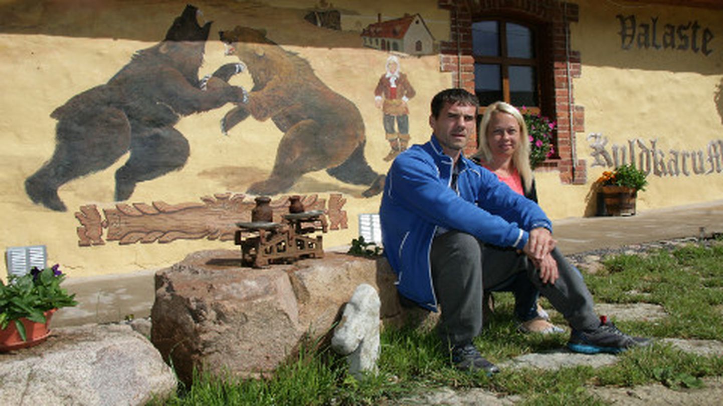 Sergei Maškin ja Tatjana Skljarova istumas improviseeritud pjedestaalil, mis on tehtud maja lähedalt korjatud looduskividest.