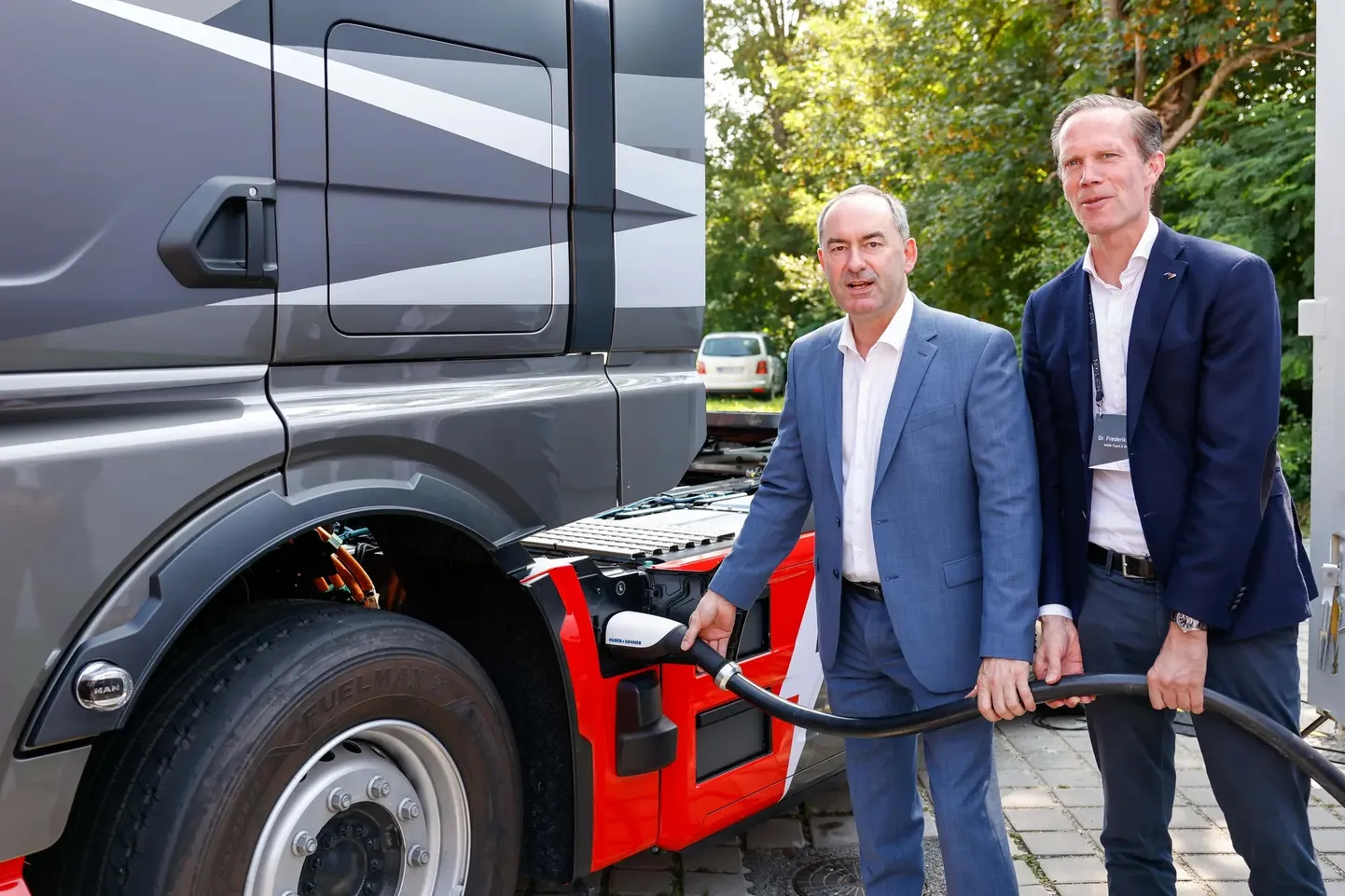 Baieri osariigi majandus-, regionaalarengu- ja energeetikaminister Hubert Aiwanger (vasakul) ning MAN Truck & Busi teadus- ja arendustegevuse eest vastutav juhatuse liige dr Frederik Zohm (paremal) ühendavad MAN eTrucki megavatise laadimissüsteemiga esimeseks avalikuks demonstratsiooniks.
