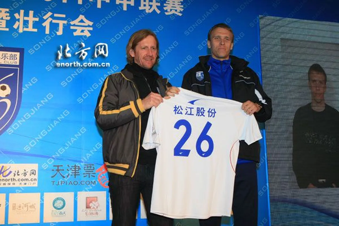 Таави Ряхн (справа) демонстрирует футболку китайского клуба.