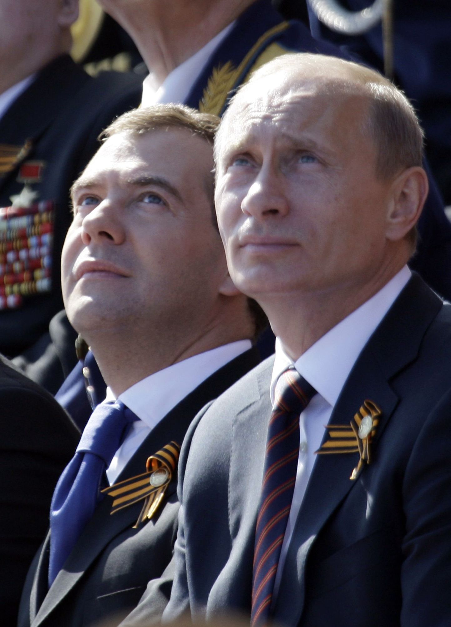 Venemaa juhttandem, peaminister Vladimir Putin ja president Dmitri Medvedev kõrvuti, mõlemal Georgi lindid rinnas, vaatamas suurt sõjaväeparaadi Moskva Punasel väljakul.
