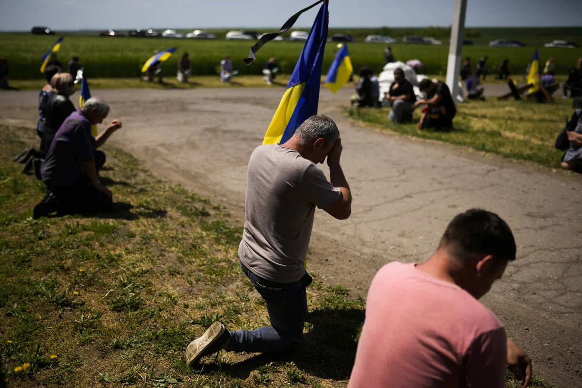 Жители ждут похоронную процессию погибшего в результате взрыва мины украинского солдата Владимира Лосева в Заре Труда, Одесская область