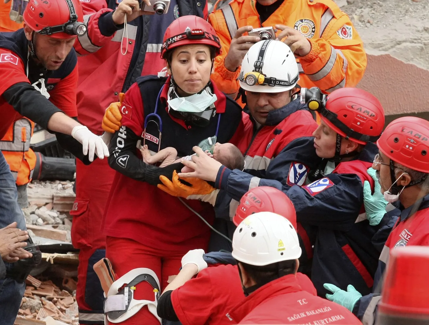 Спасатели с младенцем, обнаруженным живым под руинами.