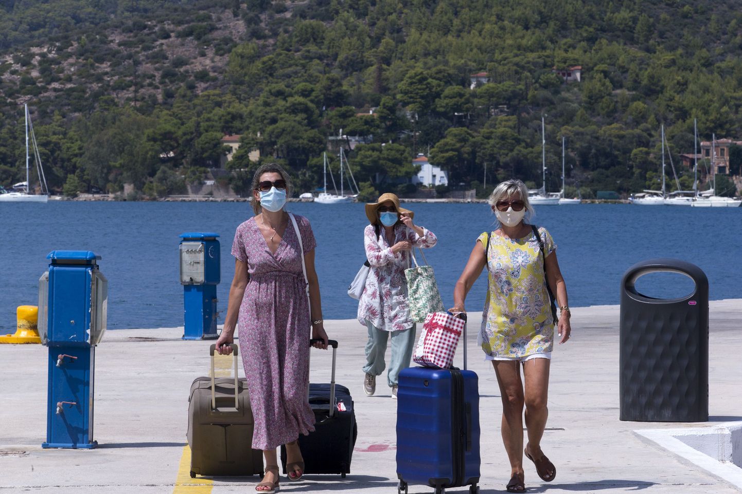 Maskides turistid Kreekas Porose saare sadamas.