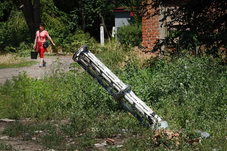 Женщина на Донбассе , на земле остатки кассетного боеприпаса