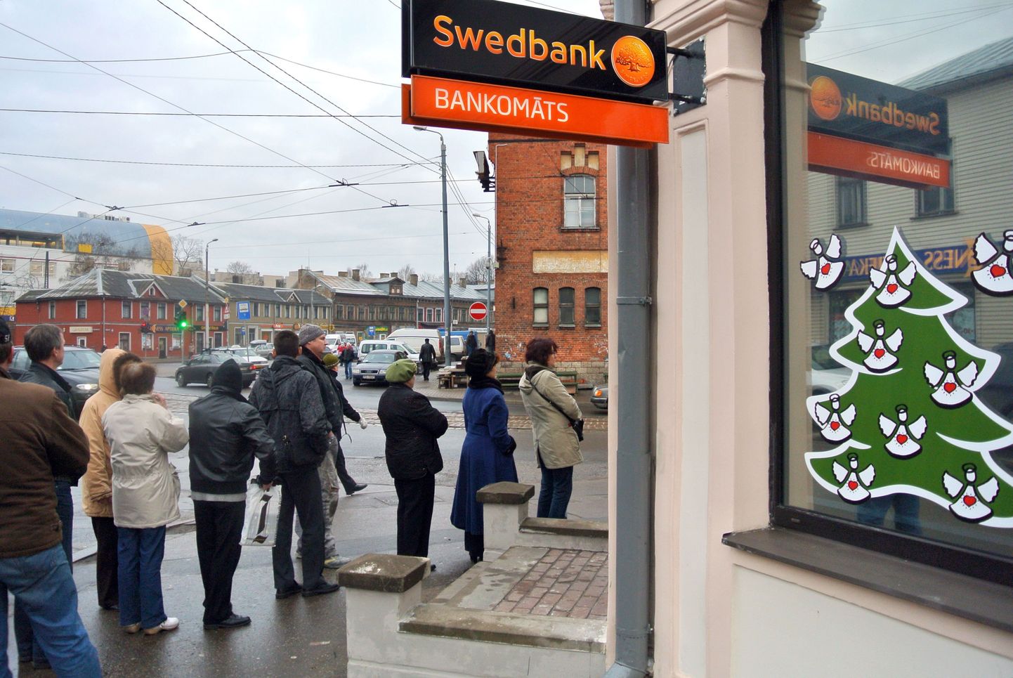 Inimesed täna Riias Swedbanki sularahaautomaadi juures järjekorras.