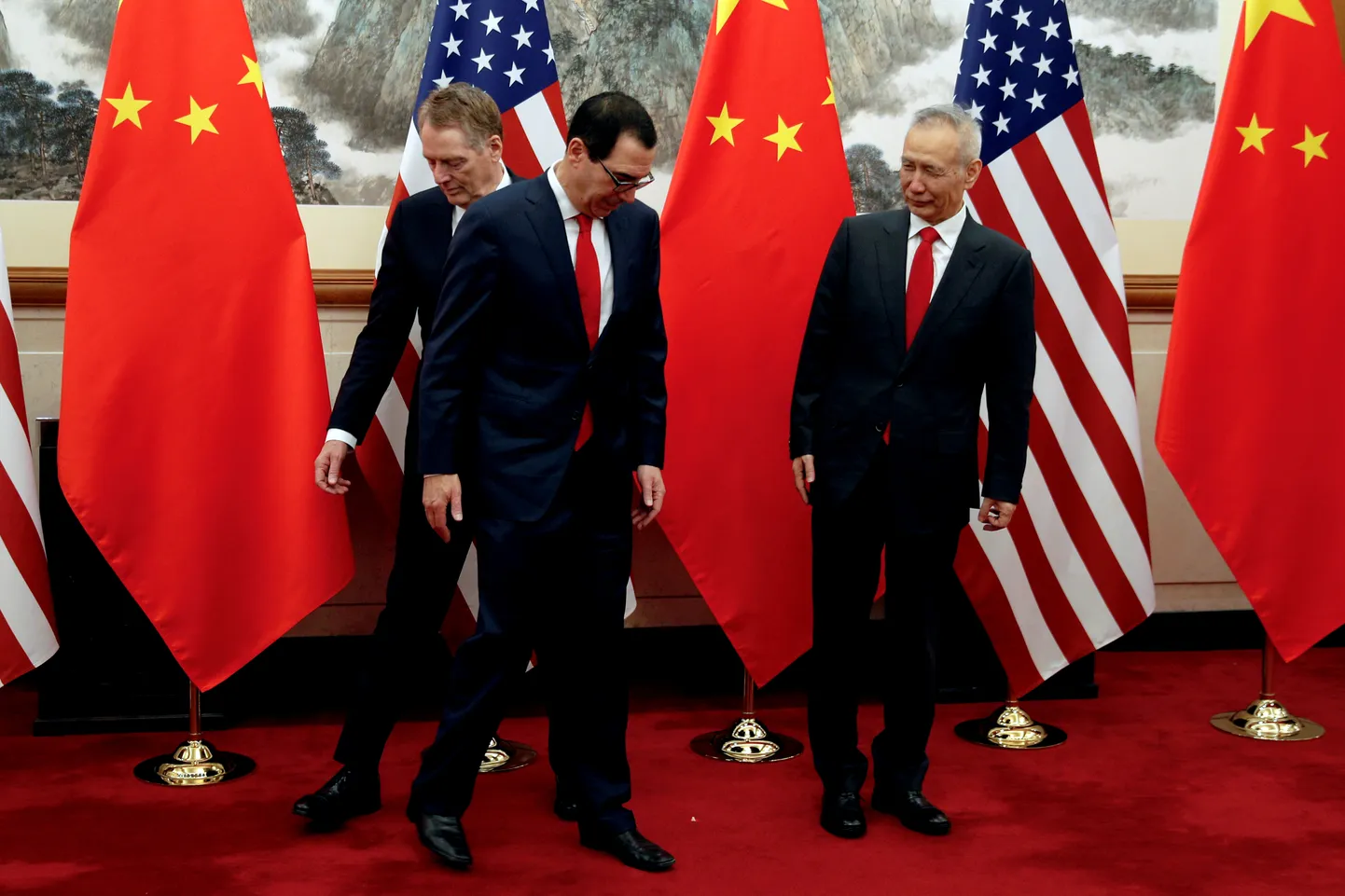 Hiina asepeaminister Liu He (paremal) vaatab pealt, kuidas USA rahandusminister Steven Mnuchin (keskel) vahetab kohti USA kaubandusesindaja Robert Lighthizeriga (vasakul) enne poolte istungit Pekingis 1. mail.