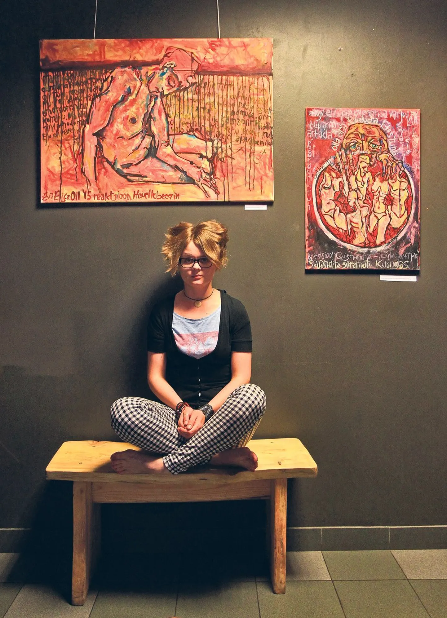 Eva Elise Oll istus kultuuriklubis Promenaadiviis (Ülikooli 1), pea kohal oma maalid «Reaktsioon Houellebecq´ile» (vasakult) ja «Sajandite surematu kuningas ehk reaktsioon Quignard´ile».