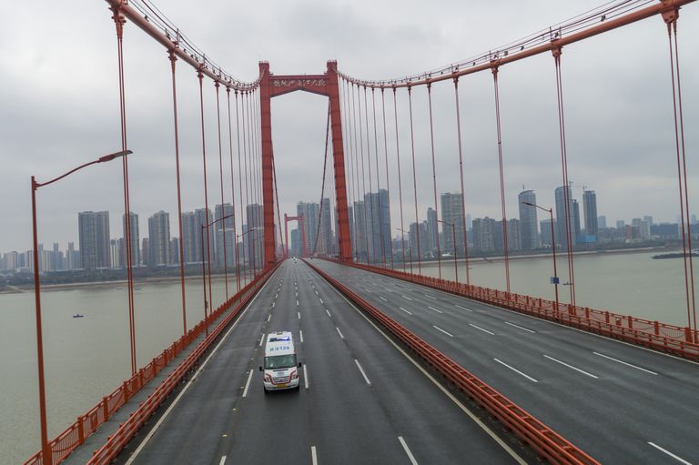 Kiirabiauto sõitmas Wuhanis üle tühja silla.