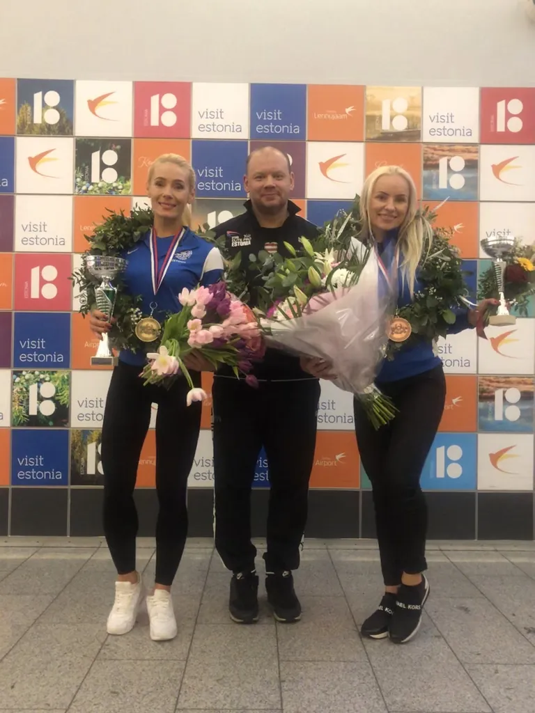 Maailmameistri saabumine Tallinna lennujaama. Bikiinifitnessi oma kategooria maailmameister Jana Teder, tema treener Sergei Popov ja pronksile tulnud Lilian Rannu.